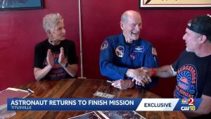 Astronaut Signs Dollar Bill
