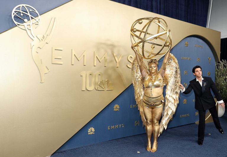 Meg Stalter Dazzles Emmy Awards Red Carpet In Gold Trophy Costume
